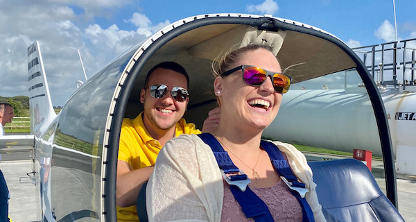 Junges Paar sitzt im Flugzeug von Fly-SPO und freut sich auf den Flug zur Hochzeit.