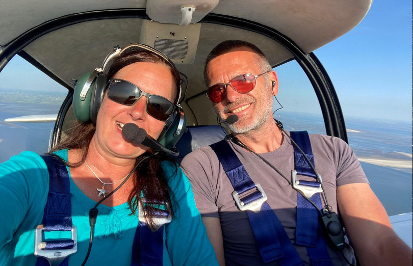 Die Piloten von Fly.SPO an Bord ihres Flugzeuges, im Hintergrund sieht man das nordfriesische Wattenmeer aus der Luft