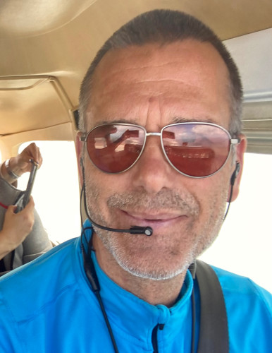 Pilot mit Sonnenbrille und Headset an Bord einer Cessna 172