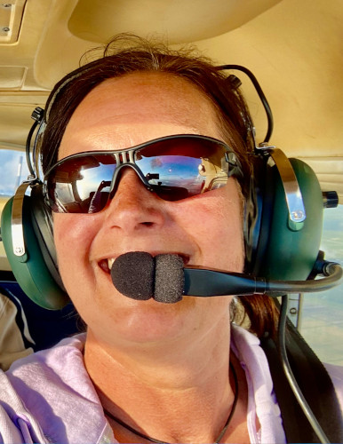 Pilotin mit Kopfhörer und Sonnenbrille an Bord einer cessna 172